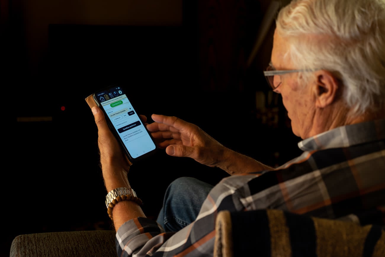 A father using WizTick grocery list app on his phone at home